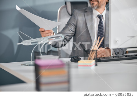 Stylish man working with papers in office Stylish man working with papers in office 68085023
