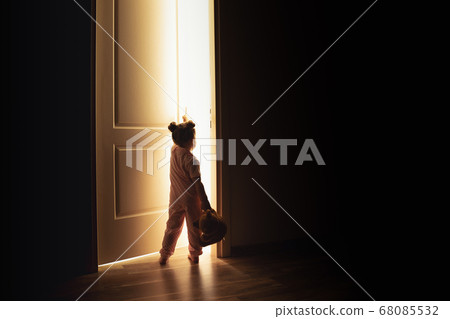 Little girl opens the door to the light in darkness Little girl opens the door to the light in darkness 68085532