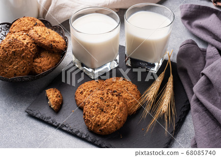 Homemade cookies cereals oats and a glass of milk on the grey concrete table. 68085740