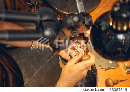Master setting a stone in a piece of jewelry Master setting a stone in a piece of jewelry 68085846
