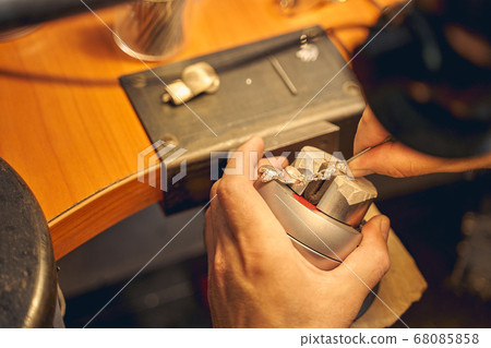 Skilled craftsman treating a new jewelry item Skilled craftsman treating a new jewelry item 68085858