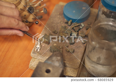 Caucasian craftsperson lifting a workpiece from the fire brick Caucasian craftsperson lifting a workpiece from the fire brick 68085929