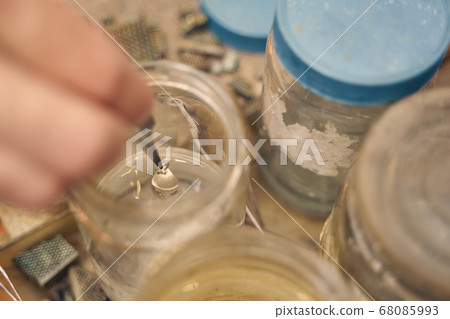 Jeweler holding a pendant with a pair of tweezers 68085993