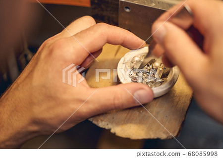 Craftsman choosing a workpiece on the crucible 68085998