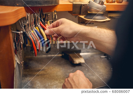 Experienced male worker selecting the right instrument 68086007