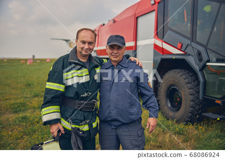 Two men from fire brigade looking at the photo camera Two men from fire brigade looking at the photo camera 68086924