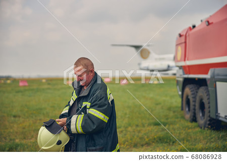 Happy smiling adult male in protective uniform standing in the field 68086928