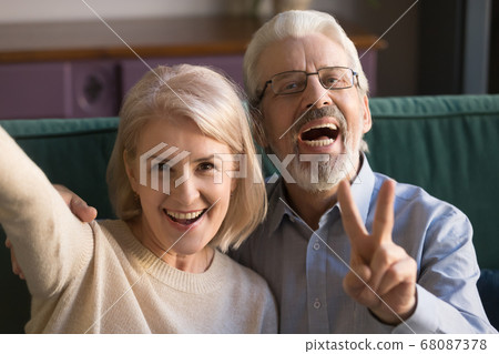 Smiling funny older couple take selfie, phone cam view Smiling funny older couple take selfie, phone cam view 68087378