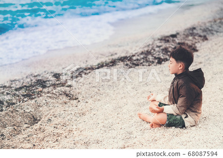 little boy Child meditating on the beach little boy Child meditating on the beach 68087594