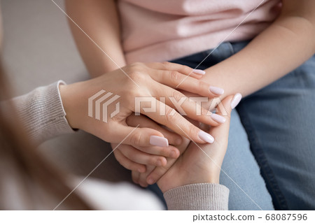 Adult woman mother holding hands of child, family trust, closeup Adult woman mother holding hands of child, family trust, closeup 68087596
