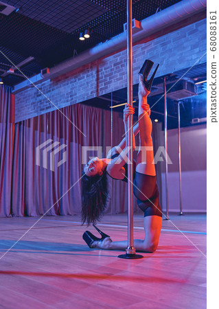 Gorgeous female dancer performing pole dance tricks 68088161