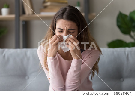 Allergic ill woman holding tissue blowing running nose Allergic ill woman holding tissue blowing running nose 68088404