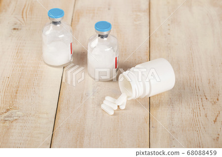 Various pill bottles and different pills on wooden table Various pill bottles and different pills on wooden table 68088459