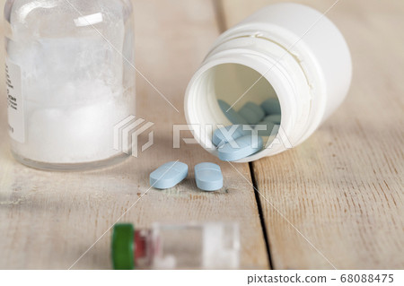 Various pill bottles and different pills on wooden table 68088475