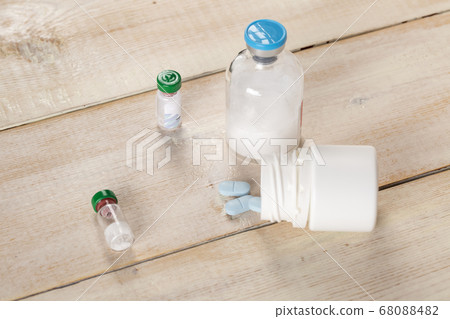 Various pill bottles and different pills on wooden table 68088482