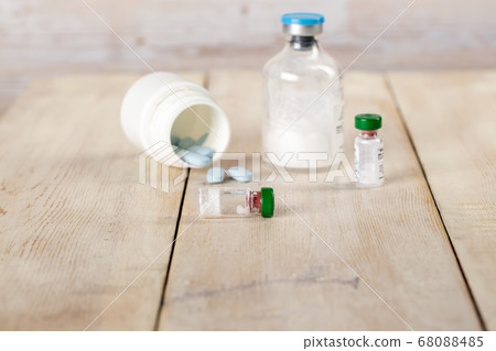 Various pill bottles and different pills on wooden table Various pill bottles and different pills on wooden table 68088485