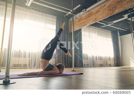 Female yoga master doing inverted locust pose 68089005