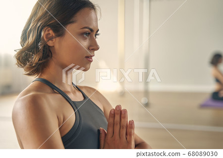 Attractive young woman meditating in yoga studio 68089030