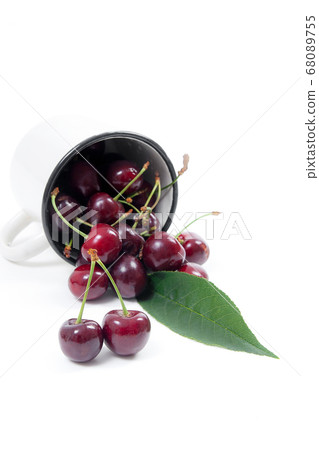 White cup with red sweet cherry isolated on a 68089755