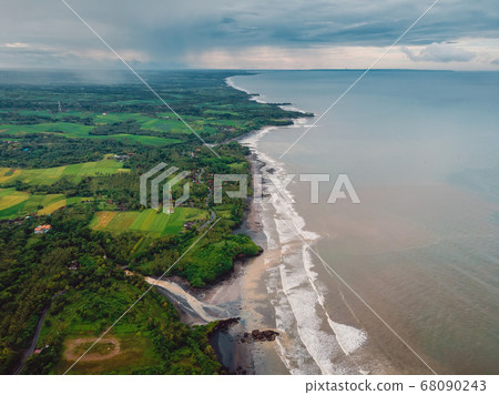 Aerial view of coastline with black sand beach, ocean and waves in Balian, Bali 68090243