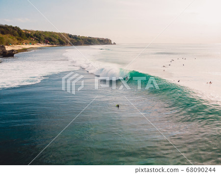 Aerial view of surfer at barrel wave. Blue perfect waves and surfers in ocean 68090244