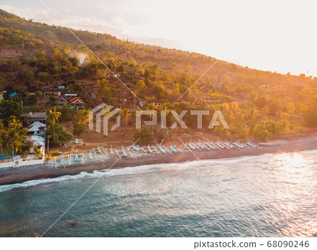 Aerial view of sea with mountains and local boats in Amed, Bali with sunset light 68090246