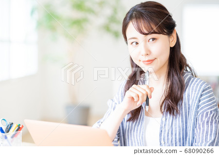Young woman doing remote work in the living room. Young woman doing remote work in the living room. 68090266