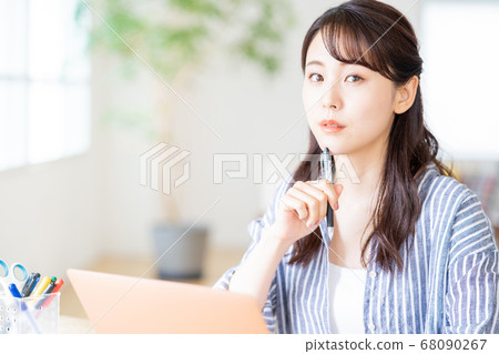 做遙遠的工作的少婦在客廳。 68090267