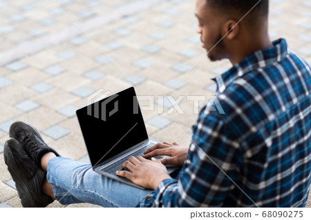 Guy using laptop, sitting on the border, mock up Guy using laptop, sitting on the border, mock up 68090275