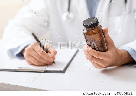 Medical doctor writing prescription for patient about pills 68090931