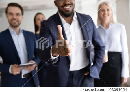 African boss holds out his hand for handshake welcoming customer African boss holds out his hand for handshake welcoming customer 68091664