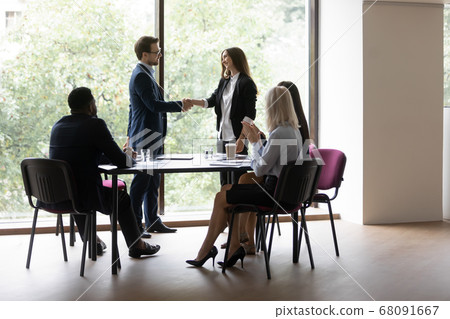 Boss express gratitude shake hands female business coach after seminar Boss express gratitude shake hands female business coach after seminar 68091667