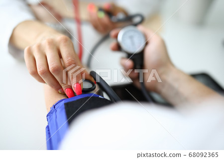 Woman's hand holds tonometer and measures patient's pressure. Woman's hand holds tonometer and measures patient's pressure. 68092365