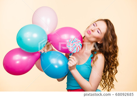 Woman with colorful balloons and lollipop 68092685