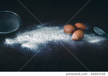 Conceptual still life photo of eggs and flour spilled on a table to show concept of baking as a way to support mental health and coping during home quarantine due to covid-19 pandemic Conceptual still life photo of eggs and flour spilled on a table to show concept of baking as a way to support mental health and coping during home quarantine due to covid-19 pandemic 68093598