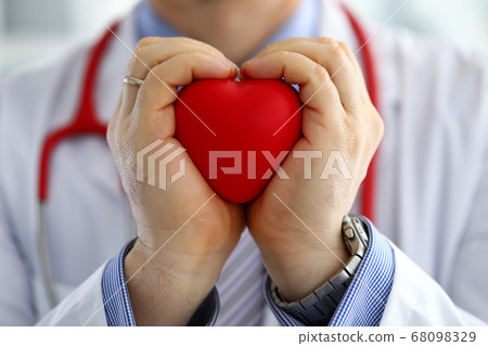 Male medicine doctor hands holding and covering red toy heart 68098329