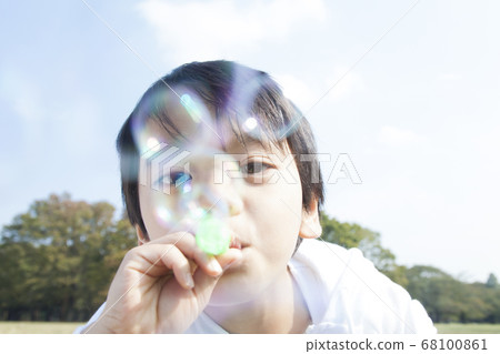 Boy blowing soap bubble Boy blowing soap bubble 68100861