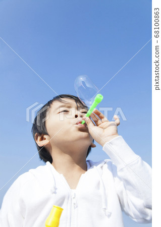 Boy blowing soap bubble 68100863