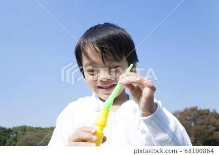 Boy blowing soap bubble 68100864