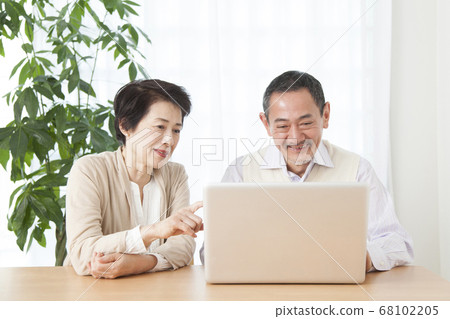 Senior couple looking at laptop Senior couple looking at laptop 68102205