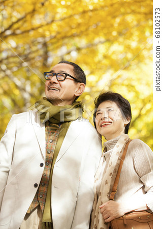 Senior couple looking at the autumn leaves 68102573