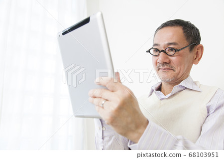 Senior men watching tablet PC 68103951