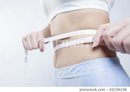 A woman measuring the waist 68106296