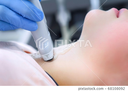 Doctor examining patient child girl thyroid gland using ultrasound scanner. 68108092