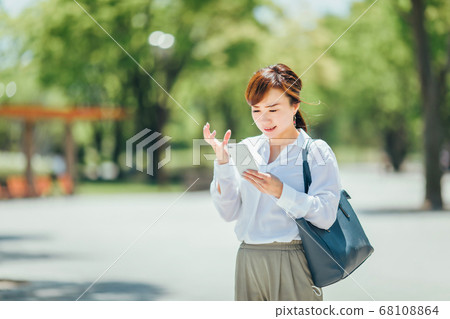 A woman angry with a smartphone A woman angry with a smartphone 68108864