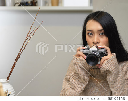 Portrait of young female taking photo while 68109138
