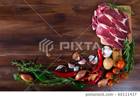 Raw beef with fresh vegetables on wooden background Raw beef with fresh vegetables on wooden background 68111437