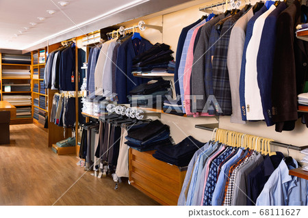 Fashion modern men clothes displayed on shelves and hanger racks in clothing store Fashion modern men clothes displayed on shelves and hanger racks in clothing store 68111627