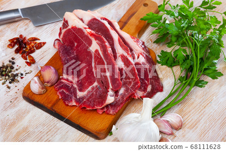Sliced raw veal steak with fresh parsley Sliced raw veal steak with fresh parsley 68111628