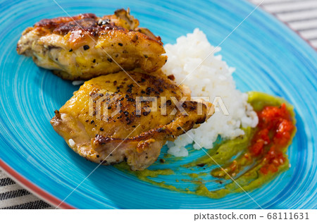 Baked chicken thighs and rice with sauces Baked chicken thighs and rice with sauces 68111631